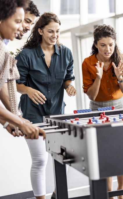 Co-workers having fun at a foosball table