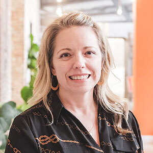 A profile photo of Christie Cooper. Long blonde hair and a black shirt.