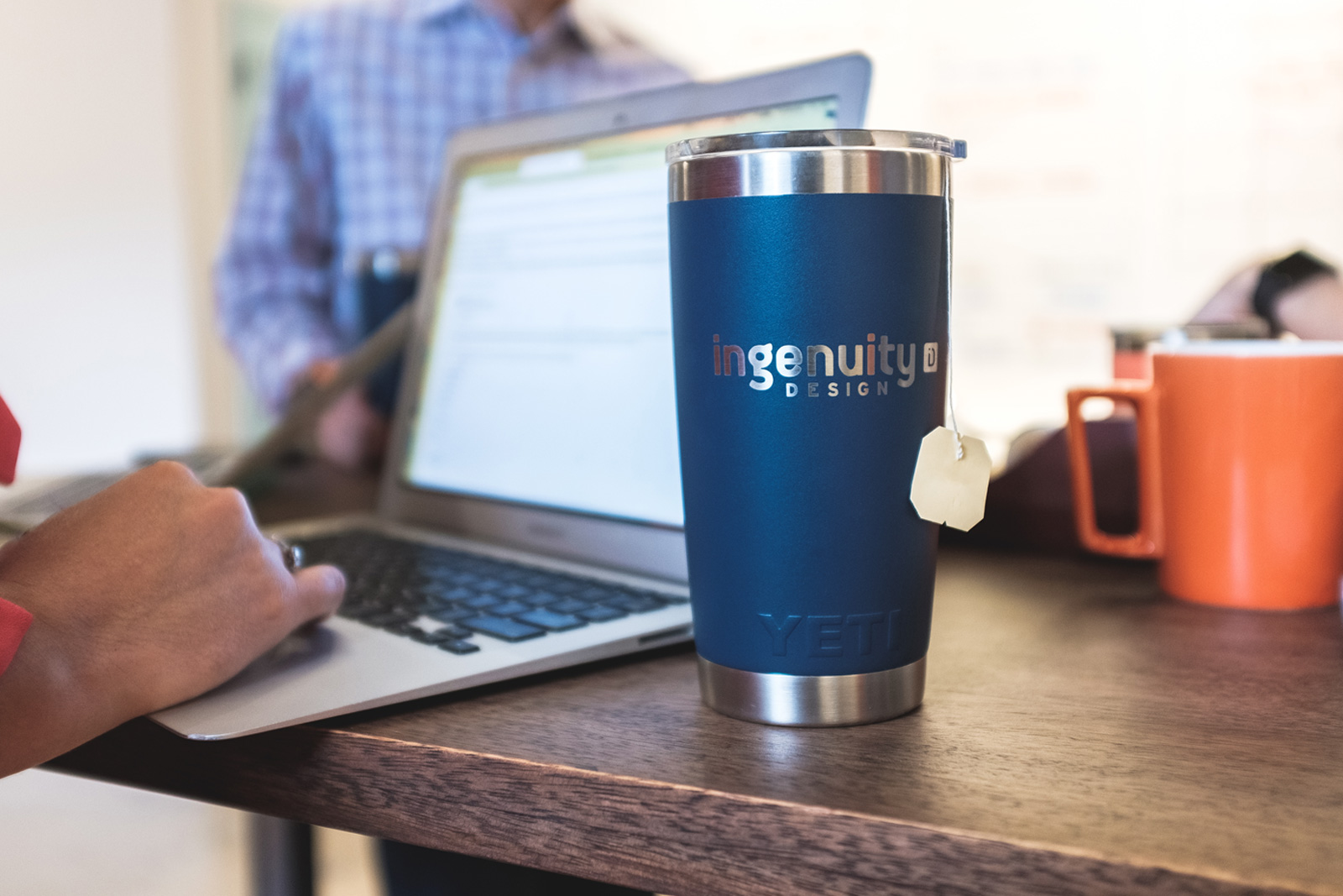 A close-up of an Ingenuity Design tumbler on a desk, reflecting everyday workplace culture and a connected office environment.
