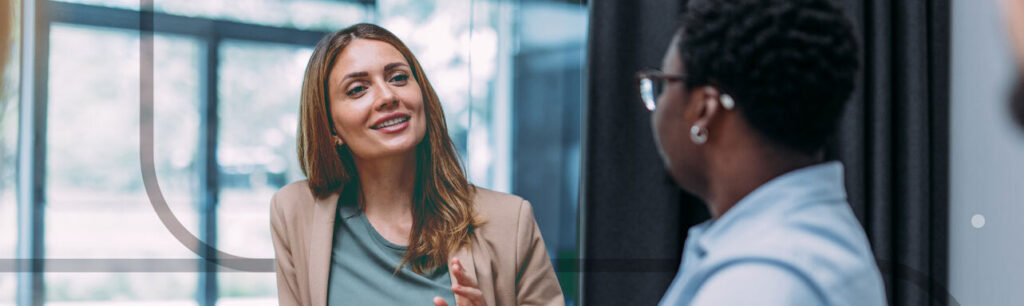 Two women sitting in a conference room, having a job interview